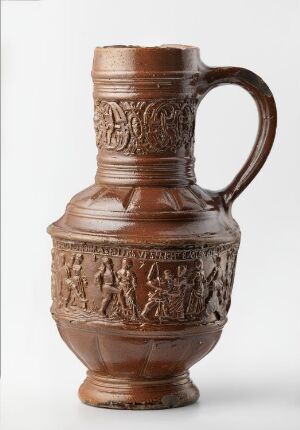 
 An antique stoneware jug called "Bondedans" featuring a salt glaze finish, with a rich reddish-brown tone and dark undertones. The jug has a detailed relief decoration depicting figures in a dance and has a decorative band around its neck, showing unknown craftsmanship.