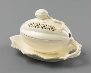  An ivory porcelain sugar bowl with a leaf-shaped base and a finely carved openwork lid, reflecting a sophisticated, nature-inspired design.