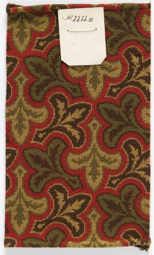  A patterned textile featuring a swirling design in maroon, olive green, and beige, with a small white label affixed in the center with a handwritten note. The intricate pattern suggests a high-end vintage fabric, possibly used for upholstery or garments.