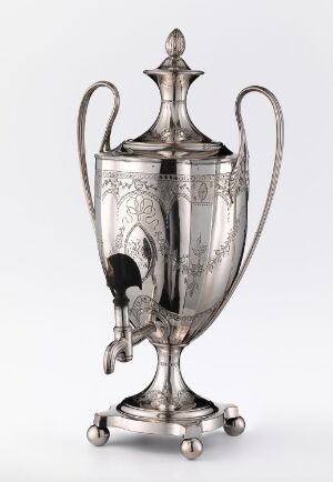  A silver samovar or hot beverage urn with ornate engravings and two handles, standing on three spherical feet, with a contrasting black tap at the front, and a pointed lid at the top, displayed against a neutral background.