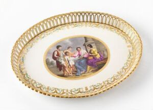  An oval decorative plate with an illustrated pastoral scene in the center, surrounded by a golden braided edge and a cream-colored rim.