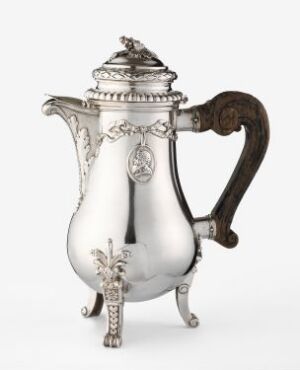  Antique silver coffee pot with ornate decorations and a dark wooden handle on a white background.