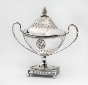  A silver sugar bowl with twisted rope handles, a square embossed base, and a lid with a finial, against a neutral background.