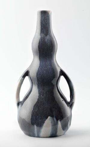  An elegantly shaped gray vase with a gradient pattern ranging from light to dark gray, featuring two looped side handles and set against a white background.