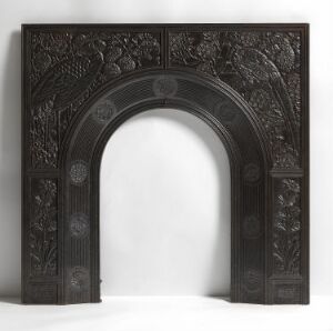  A grayscale image of an intricately carved archway with symmetrical floral patterns on the two vertical panels and semicircular top, suggestive of skilled craftsmanship and a monochromatic aesthetic.