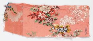  An antique floral textile artwork on soft coral pink background featuring a bouquet of lush roses in crimson and other colorful flowers in shades of yellow, blue, green, and purple, evoking a traditional European design.