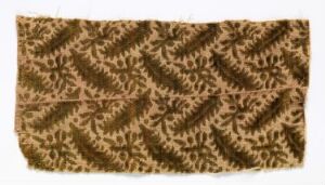  A rectangular piece of fabric with an intricate pattern of symmetrical fern-like designs in shades of brown over a beige background.