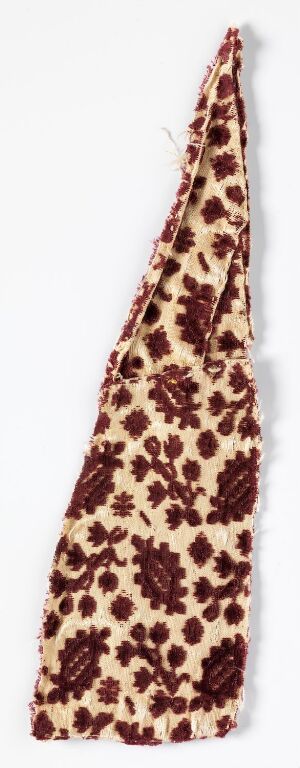  A narrow, folded piece of fabric featuring a creamy-beige background with a repeated dark brown floral or paisley-like pattern, giving a classic and possibly traditional appearance.