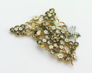  A decorative jewelry piece resembling a bouquet of golden flowers and leaves accented with white and green, with a detailed butterfly on one side, set against a plain neutral background. Artistname and title unknown.