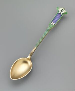  A decorative spoon with a golden bowl and a handle featuring a color gradient from gold to green to blue, topped with a floral motif in purple and green, set against a light grey background. Artist and title are unknown.