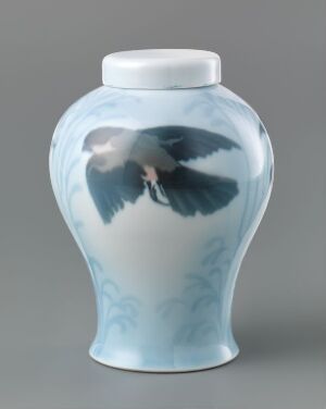  A porcelain vase by Porsgrunds Porselænsfabrik AS with a pale blue glaze and a hand-painted underglaze motif of a bird in flight, highlighted by darker shades of blue against a subtly decorated background.