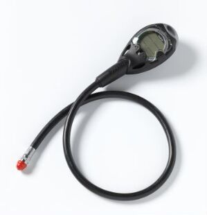  A circular industrial measuring device by Suunto Oy with a black housing and an analog cream-colored gauge in the center, connected to a flexible black cord with a red connector, set against a light background.