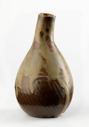  A ceramic vase with a narrow base and mouth, and a wide, rounded body featuring a marbled pattern of earthy browns and soft beige streaks against a plain, light background.