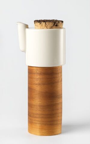  A modern tableware pitcher by Tonfisk Design Oy, with a form-bent walnut laminate body, off-white matte ceramic top, cork lid, and a simple, minimalist handle and spout.