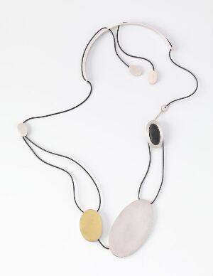  "Balansepunkt II" by Millie Behrens, a silver necklace with a brushed and partly gilded surface showcasing an inset stone, strung on a nylon thread against a white background.