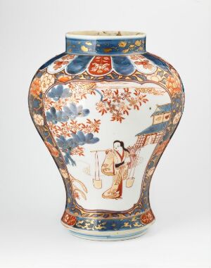  A traditional ceramic vase with a white background and intricate decorations, including a central scene of a figure in Eastern attire, surrounded by blue foliage, and a band with heraldic motifs. Accents in blue, red, orange, and gold hues adorn the vase.