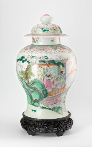  An ornate porcelain vase with a lid, featuring painted scenes with figures in traditional attire and floral designs in soft greens, pinks, and blues, placed on a dark intricately carved stand.