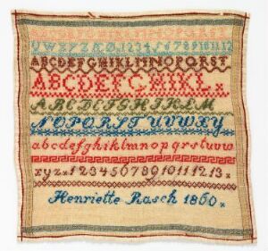  An antique hand-embroidered sampler with rows of the alphabet and numbers in various colors and fonts, including a final inscription, "Henriette Rauch 1860," on a cream-colored background displaying signs of aging.