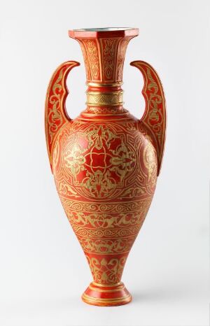  An ornately patterned terracotta vase with a flared lip and slender neck, boasting intricate golden-orange designs with a central emblem, evoking a sense of traditional craftsmanship.