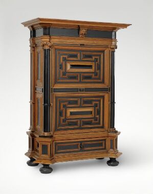  An elaborately designed antique wooden secretary desk, with dark brown tones highlighted by lighter brown trims, featuring multiple drawers and compartments. The desk stands on carved wooden feet and has an air of historical elegance.