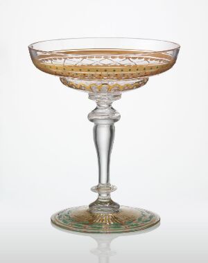  A stemmed glass with a wide, shallow bowl, adorned with golden speckles and a decorative pattern along the rim, set against a plain background.