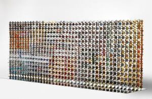  "Blikk-Fang" – A wall structure crafted from cut and assembled pieces of aluminum derived from tin can materials, showcasing a colorful mosaic pattern of various metallic hues and reflecting light in a textural, three-dimensional display. Artist name unknown.