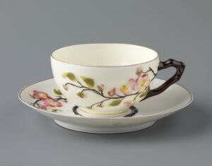  Porcelain teacup and saucer with pastel floral design, "Rosengren" by Porsgrunds Porselænsfabrik AS, featuring off-white color, relief-decorated with enamel colors and gold accents.