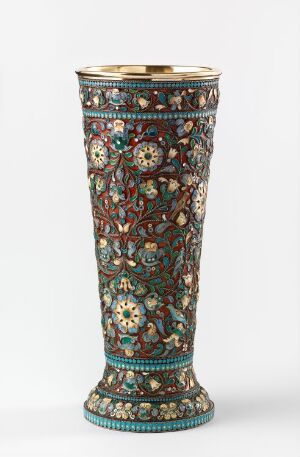  A highly detailed and ornate enamel vase featuring intricate floral patterns in vibrant colors of green, red, blue, and white, with gold linework throughout, against a plain light background.