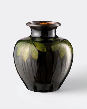  An elegant vase with a deep, smoky black base featuring artfully rendered green leaf designs, set against a light grey background. The leaves display varying shades of green, and the rim of the vase has a warm, brownish glow. The artist's name and title are unknown.