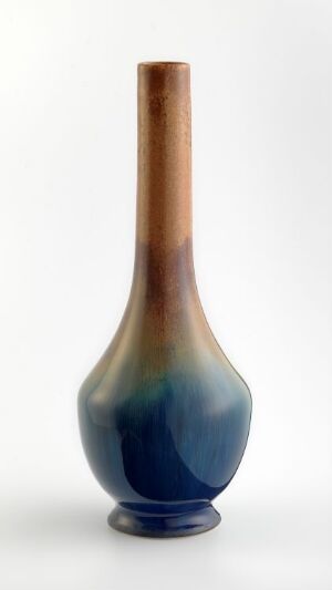  A tall, slender ceramic vase with a glossy finish, featuring a gradient of colors starting with cobalt blue at the base, transitioning to teal, then green, and finally to a toasted almond brown at the elongated neck, against a white background. Artistname and title are unknown.