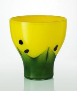  A glass object titled "Krokus" designed by Kari Ulleberg, featuring blown colored glass that transitions from a rich green base to a sunny yellow top with black, crocus petal-like accents.