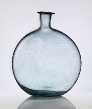  A round aquamarine glass bottle with a textured pattern, slender neck, and flared opening, against a soft white gradient background, showcasing its simple elegance and hint of historical craftsmanship.