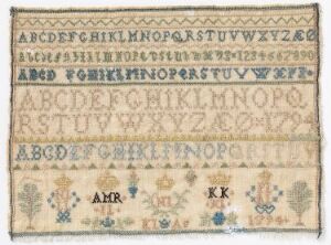  An antique needlework sampler featuring four alphabets in upper case letters, stitched in shades of blue and brown, with small decorative floral motifs and initials "AMR," "KK," and "IK" at the bottom, on a cream-colored aged linen background.