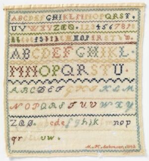  An image of a vintage needlework sampler featuring rows of the alphabet in uppercase and lowercase, numbers, and decorative stitch patterns in a variety of pastel colors on an off-white background with slightly frayed edges.