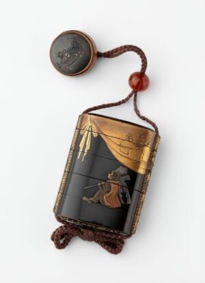  An antique Japanese black lacquer inro with gold decorative elements and a reddish-brown woven cord featuring a large bead, resting on a white background.