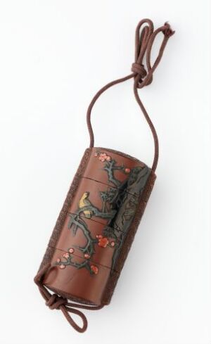  An elongated, cylindrical brown case with a leather-like texture and a looped cord, adorned with intricate designs featuring natural motifs in red and green on a dark background.