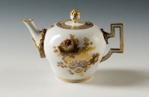  An antique white porcelain teapot with gold, brown, and tan floral decorations, a gold-painted angular handle, and spout set against a light gray background.