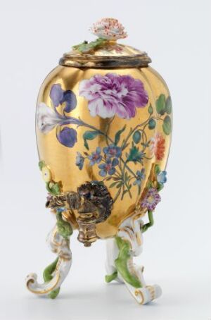  A decorative oval-shaped object with a golden yellow body and ornate floral designs in purple, blue, and green, accented with red and white. The object has gilded details and stands on three curved, leaf-designed legs, set against a white background.