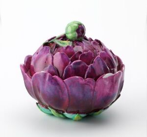  A ceramic artichoke with realistic detailing, featuring deep purple and magenta scales that fade to pink and are accented with green at the base and top, set against a white background.