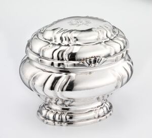  An image of a silver sugar bowl titled "Sukkerskål" by Jonas Hendrich Jonassen, showcasing a reflective, sculpted surface with a concentric design, set against a neutral background.