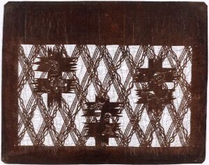  A rectangular object with a dark brown background featuring intricate, lighter brown carved patterns in the center with a lattice design surrounding them. The craftsmanship suggests a handmade or ceremonial item. No specific artist or title information is available.