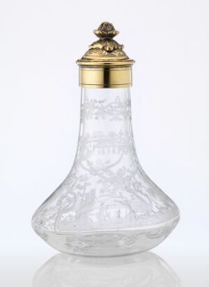  An ornate clear glass bottle with a decorative golden cap, featuring embossed designs on its body, set against a plain white background. Artistname and title are unknown.