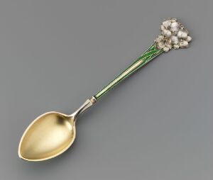  "Mokkaskje" by David-Andersen, a gilt silver spoon with a golden reflective bowl and an intricate green guilloche enamel handle, ending in a detailed gilt silver cluster that resembles a floral motif.