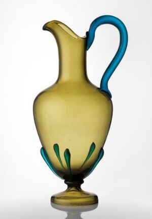  An elegantly designed glass vase with a smooth olive or mustard yellow body, highlighted by a cobalt blue handle and delicate blue vertical lines near the base, standing against a neutral background.