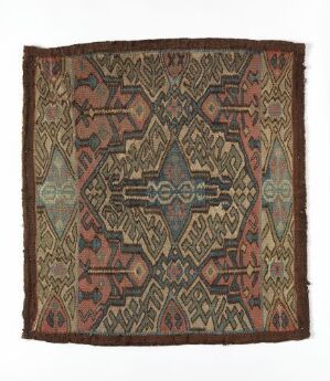  A square textile with intricate geometric and stylized patterns in earthy tones of brown, beige, terracotta, dark red, and forest green, featuring two central diamond-shaped medallions connected by linear motifs.