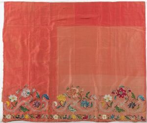  A lightweight translucent textile with a red background, featuring a detailed multi-colored floral embroidery border along the bottom edge, with no artist name or title provided.