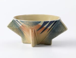  A hexagonal ceramic bowl by Egersunds Fayancefabrik with a creamy yellow interior and an abstract spray-decor exterior in shades of dark green, navy blue, and rusty orange. The bowl features a glossy finish and an artistic design characteristic of støpt og glasert flintgods.