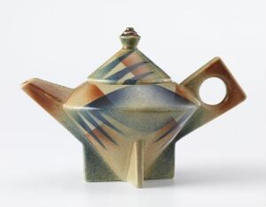  Ceramic teapot by Egersunds Fayancefabrik, crafted from flint ware with a glazed surface and spray-on decor. The teapot exhibits a geometric form with angular shapes and features a blend of earthy tones with detailed linear patterns in darker colors, and it includes a prominent spout and a looped handle.