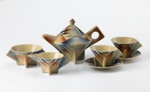  A set of mid-century modern style glazed flintware tableware by Egersunds Fayancefabrik, including a teapot with a geometric design, four slanted cups, and a saucer in muted earth tones with a sprayed decorative pattern.