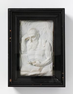  "Eremitt" by Magnus Berg, a relief-carved ivory sculpture on an oak panel framed under glass with a black wooden frame. The intricate carving depicts a contemplative figure in a pale, creamy-white ivory set against the dark wooden background, encased in a stark black frame that highlights the detailed artwork.